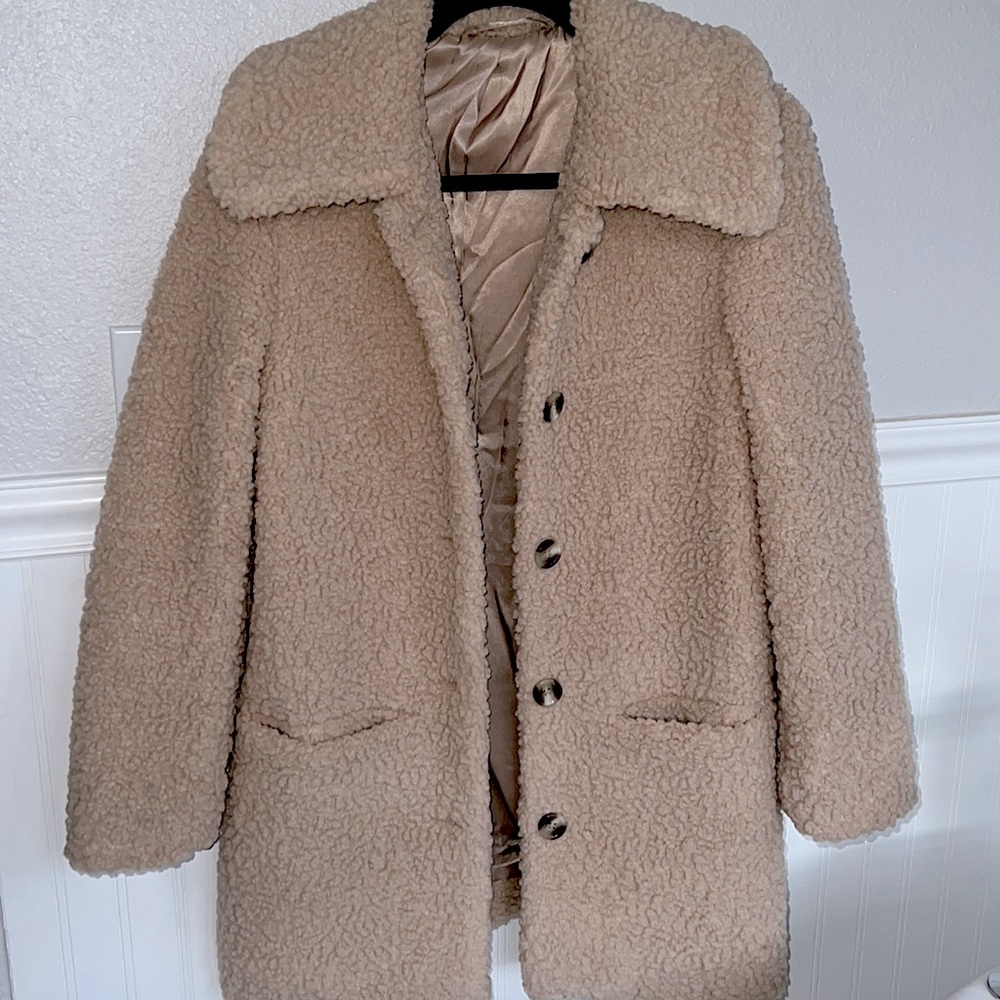 Women's beige coat in teddy fabric perfectly lined with pockets in the front